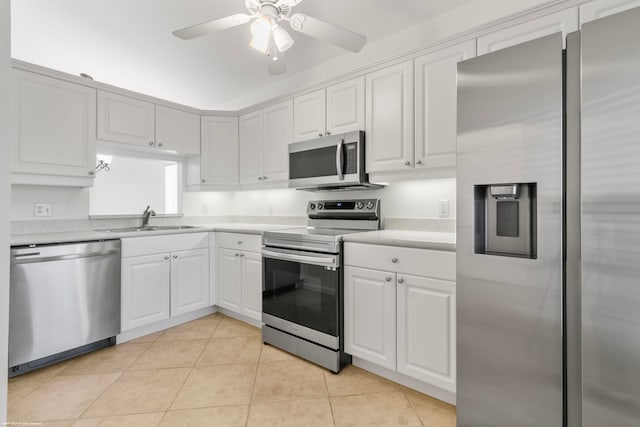 kitchen with sink, light tile patterned flooring, white cabinetry, ceiling fan, and stainless steel appliances