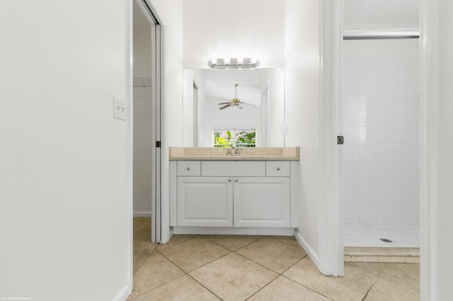 bathroom with vanity, tile patterned flooring, ceiling fan, and tiled shower