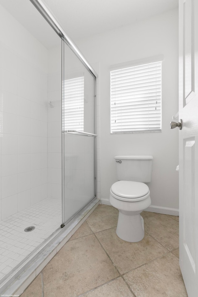 bathroom with toilet, tile patterned flooring, and an enclosed shower