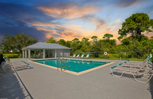 pool at dusk with a patio