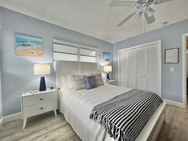 bedroom featuring light wood-style floors, a closet, baseboards, and a ceiling fan