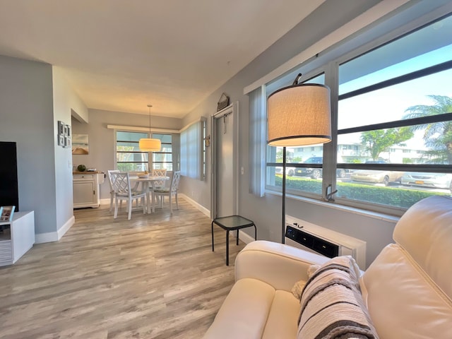 living area with baseboards and light wood finished floors