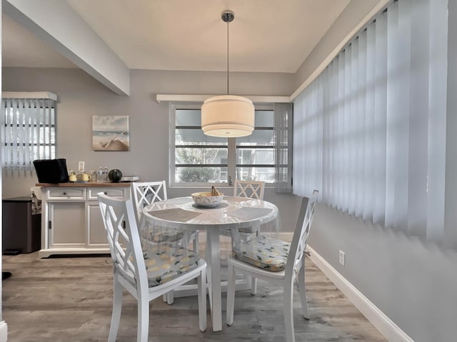 dining area with baseboards and wood finished floors