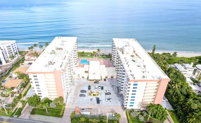 birds eye view of property with a water view and a beach view