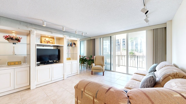 living room with a textured ceiling, light tile patterned floors, and rail lighting