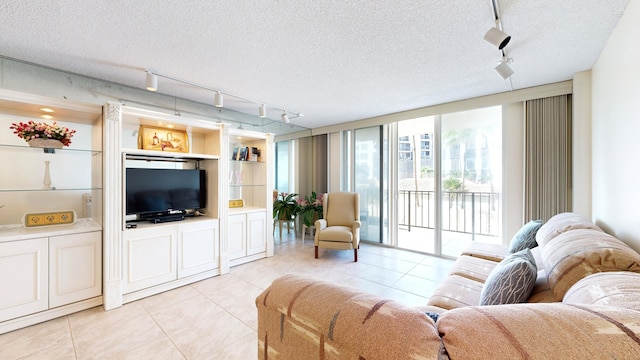 living area featuring expansive windows, a textured ceiling, built in shelves, and light tile patterned floors
