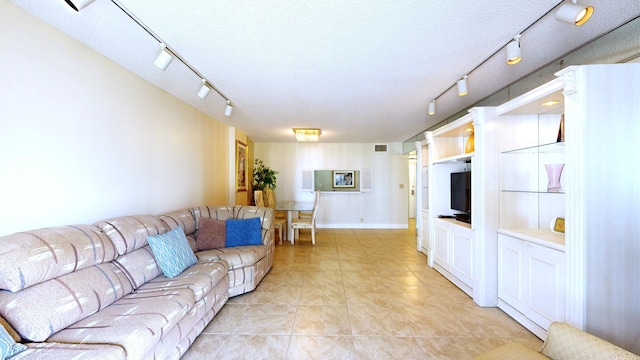 living area featuring visible vents, rail lighting, light tile patterned floors, and a textured ceiling