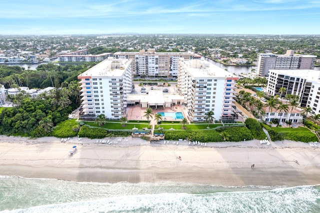 drone / aerial view featuring a city view, a view of the beach, and a water view