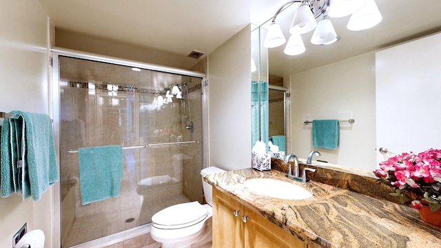 bathroom featuring tile patterned flooring, vanity, toilet, and a shower with shower door