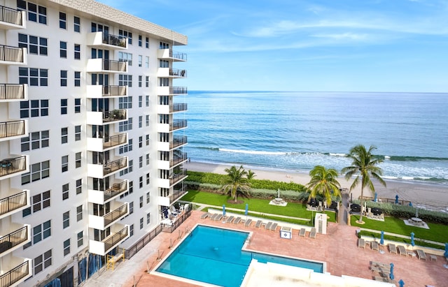 community pool with a water view and a view of the beach