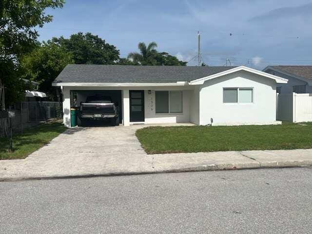 ranch-style home with a garage and a front lawn