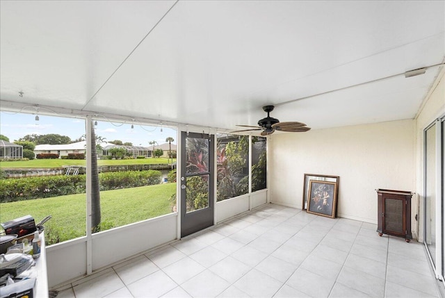 unfurnished sunroom with a water view and ceiling fan