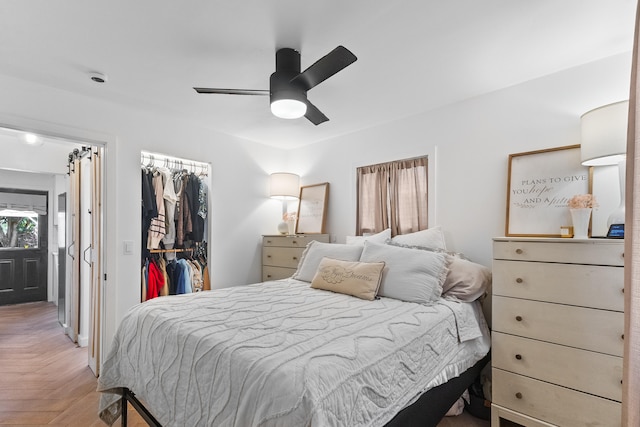 bedroom featuring a closet, ceiling fan, and parquet floors