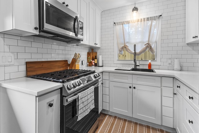 kitchen with white cabinets, stainless steel appliances, and backsplash