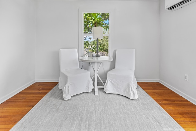 dining room with a wall unit AC and hardwood / wood-style floors