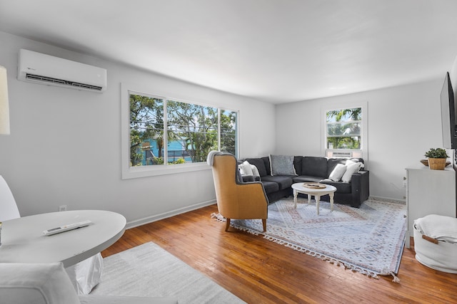 living room with an AC wall unit and light hardwood / wood-style floors