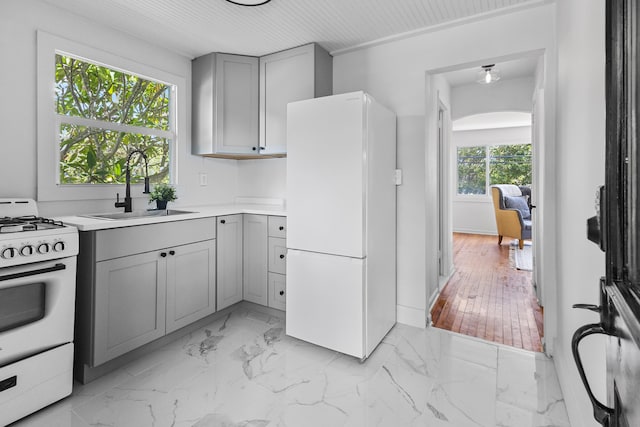 kitchen featuring gray cabinetry, wooden ceiling, sink, light wood-type flooring, and white appliances