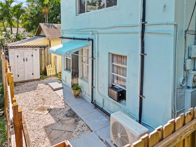 view of property exterior featuring ac unit and a storage shed