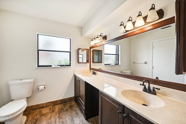 bathroom with hardwood / wood-style floors, vanity, and toilet