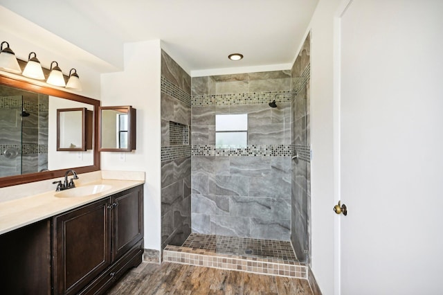 bathroom featuring a tile shower, vanity, and hardwood / wood-style floors