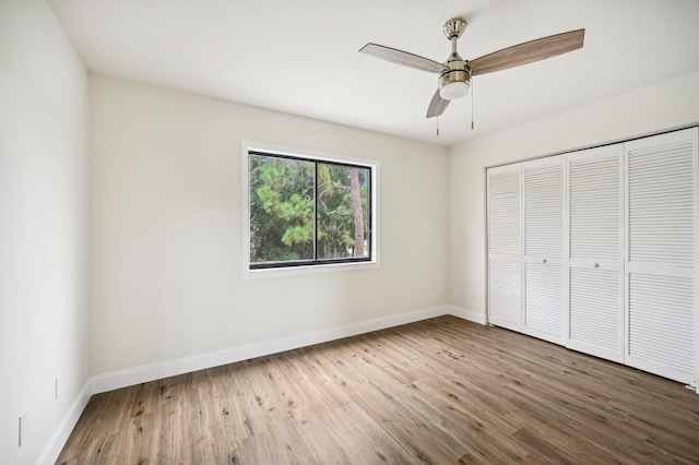 unfurnished bedroom with wood-type flooring, ceiling fan, and a closet