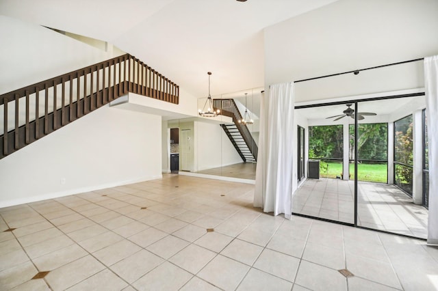 interior space with ceiling fan with notable chandelier, high vaulted ceiling, and light tile patterned floors