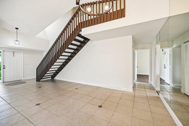 tiled entrance foyer featuring a towering ceiling