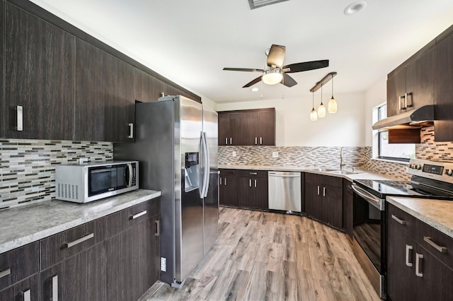 kitchen featuring appliances with stainless steel finishes, light wood-type flooring, ceiling fan, and tasteful backsplash