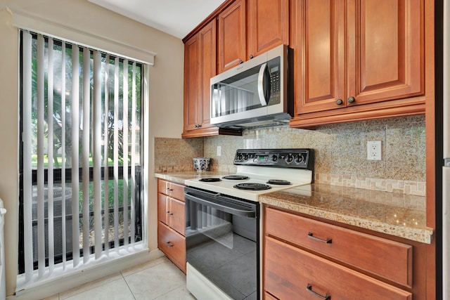 kitchen featuring electric stove, backsplash, and light tile patterned floors