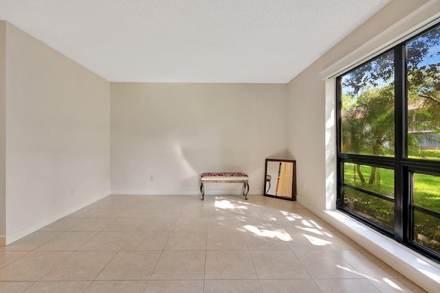 tiled spare room featuring a textured ceiling