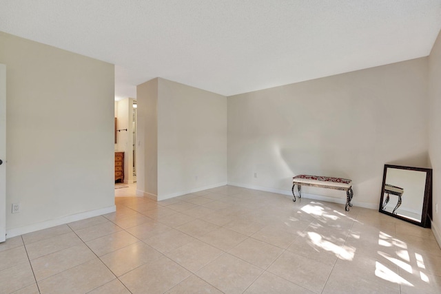 tiled empty room with a textured ceiling