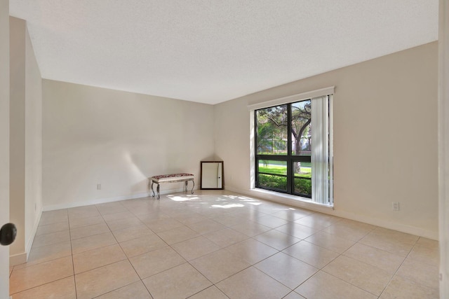 tiled empty room with a textured ceiling