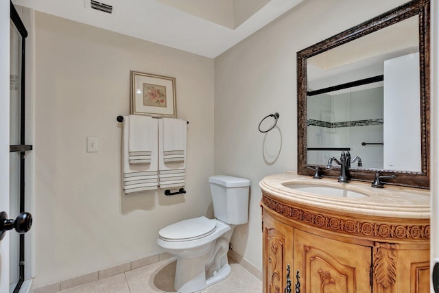 bathroom featuring tile patterned flooring, vanity, a shower with door, and toilet