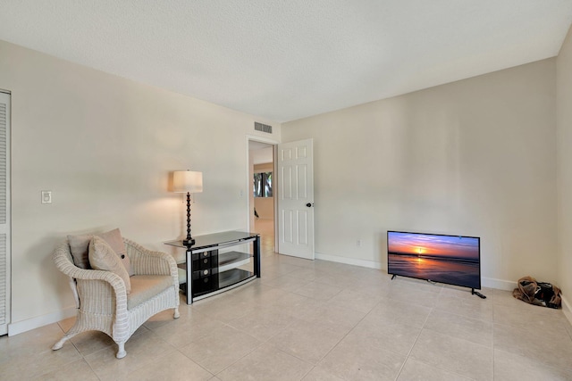 sitting room with light tile patterned floors and a textured ceiling