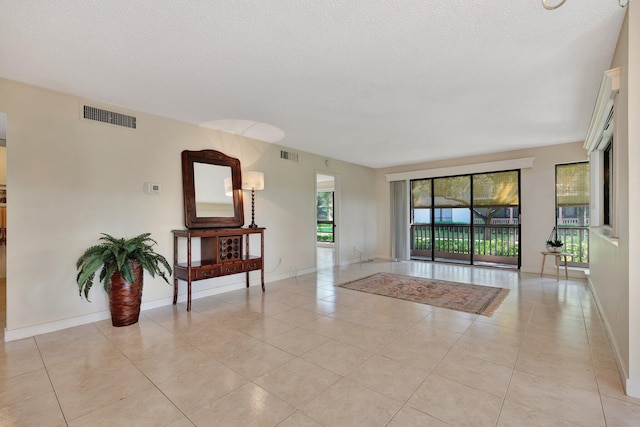 spare room featuring light tile patterned floors and a textured ceiling