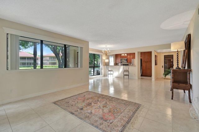 foyer entrance with light tile patterned floors, a textured ceiling, and an inviting chandelier