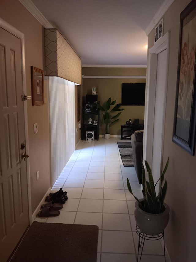 corridor featuring ornamental molding and light tile patterned floors