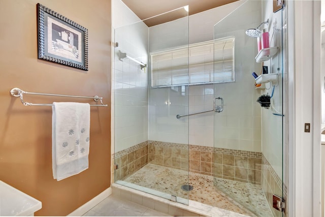 bathroom with a shower with door and tile patterned floors