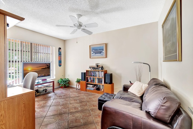 living room featuring ceiling fan and a textured ceiling