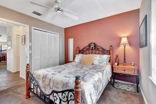 bedroom with carpet floors, a textured ceiling, a closet, and ceiling fan