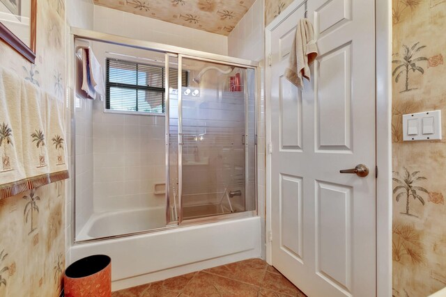 bathroom featuring combined bath / shower with glass door and tile patterned flooring