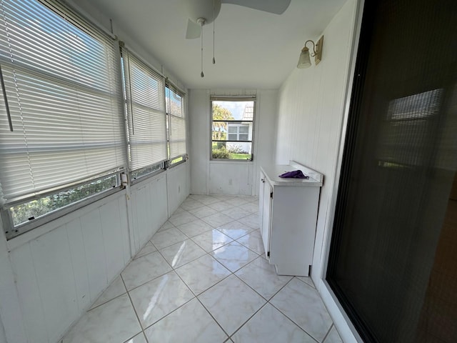 tiled living room with ceiling fan and sink