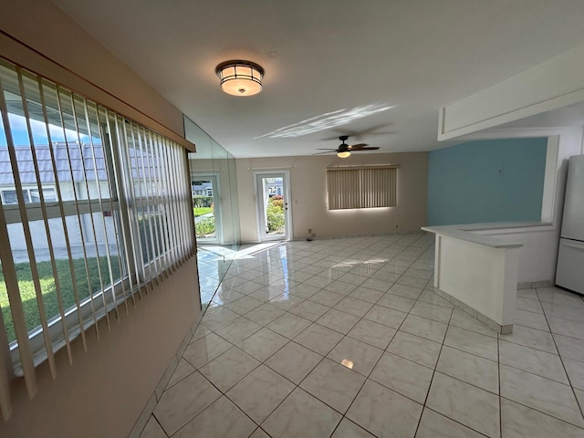 spare room with ceiling fan and light tile patterned floors