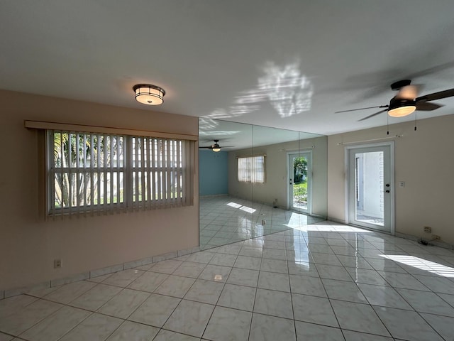 tiled spare room featuring ceiling fan