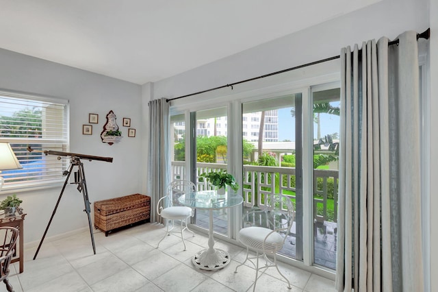 entryway featuring baseboards, light tile patterned floors, and a wealth of natural light