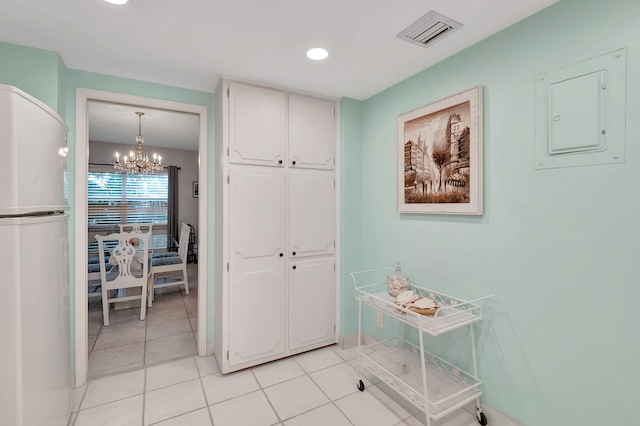 hallway with an inviting chandelier, recessed lighting, light tile patterned floors, visible vents, and electric panel
