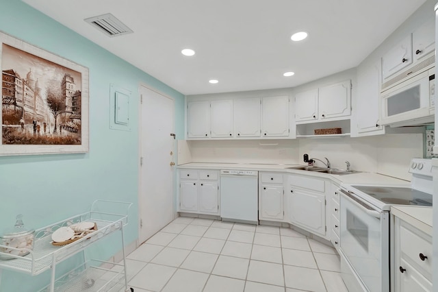 kitchen with a sink, white cabinets, white appliances, and visible vents