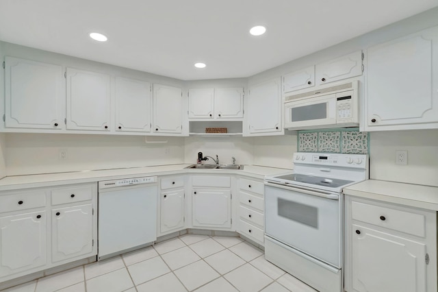 kitchen with white appliances, light countertops, white cabinets, a sink, and light tile patterned floors