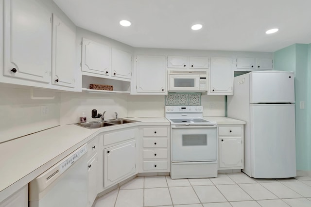 kitchen with white appliances, white cabinetry, sink, and light tile patterned flooring