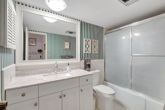 full bathroom featuring vanity, combined bath / shower with glass door, visible vents, and toilet